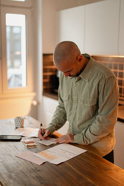 istock Man Managing Finances And Writing Amounts 2249408125