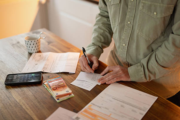 istock Person Completing Payment Information Beside Money 2249408160