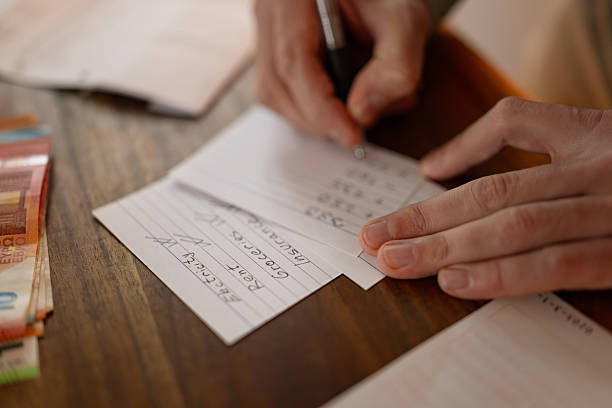Realistic budgeting moment showing a man writing down payment details for household expenses.