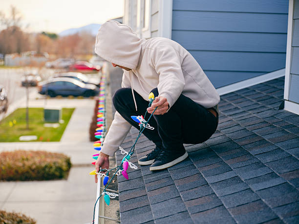 istock Man Installing Christmas Lights on a Home 2249408834