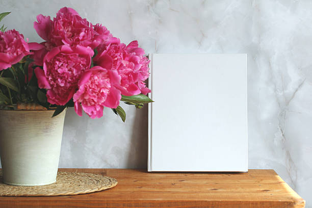 istock White book mockup standing next to pink peonies 2249409535