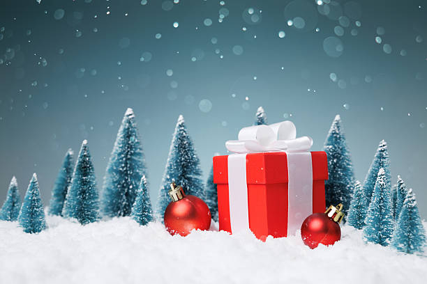 istock Red gift box on snow with Christmas baubles and miniature trees, copy space 2249409792