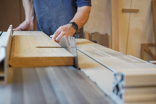 istock Middle-aged carpenter cutting wood on a circular saw 2249411095