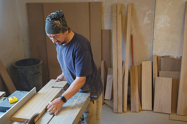 istock Middle-aged carpenter cutting wood on a circular saw 2249411249