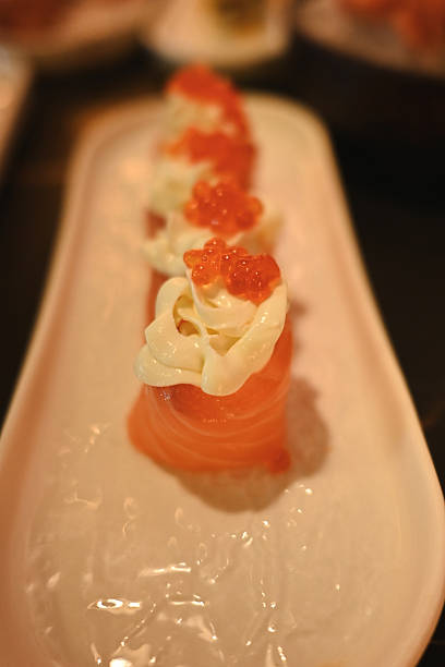 Delicious japanese salmon sushi with creamy topping and red roe on a plate