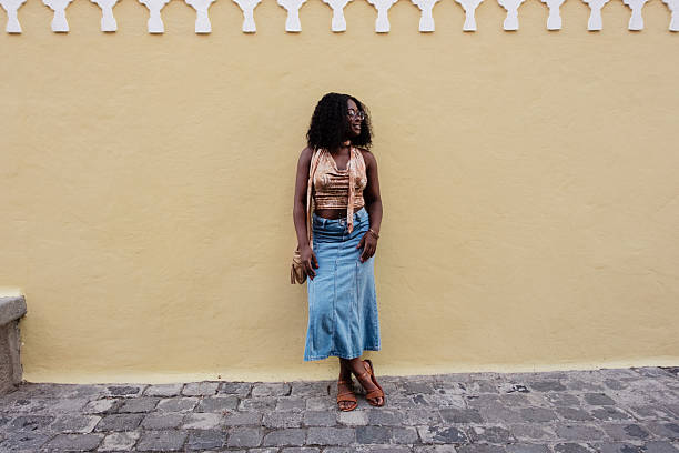 istock Young woman posing against yellow wall looking away 2249417685