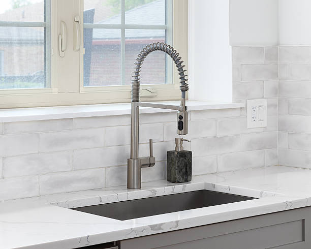 istock A kitchen faucet detail with a grey cabinet and subway tile backsplash. 2249418046