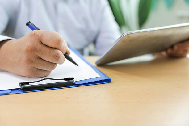 istock Close-Up Of Professional Taking Notes At Desk 2249419742