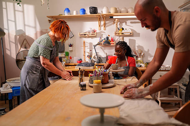istock Three artisans working diligently in a pottery workshop, shaping and molding clay into unique ceramic creations, showcasing their craftsmanship and artistic skills 2249420177