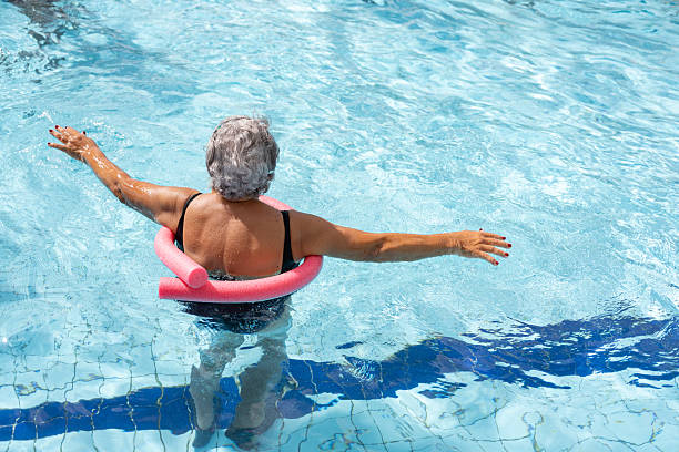 Elderly woman doing water aerobics in the pool