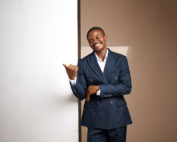 istock Studio portrait of smiling man in pinstripe suit leaning on white panel 2249426121