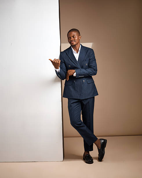 istock Full-length studio portrait of man in pinstripe suit leaning on white panel 2249426175