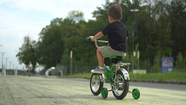 Girl learning to ride a bike in the garden of the site