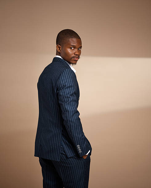 istock Side-view studio portrait of man in pinstripe suit looking over shoulder 2249427678