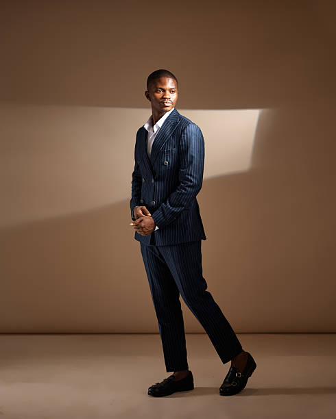 istock Man in pinstripe suit standing in dramatic studio lighting 2249428191