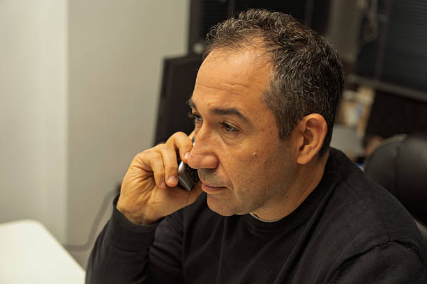 istock Mid-adult man communicating on phone in office 2249429284