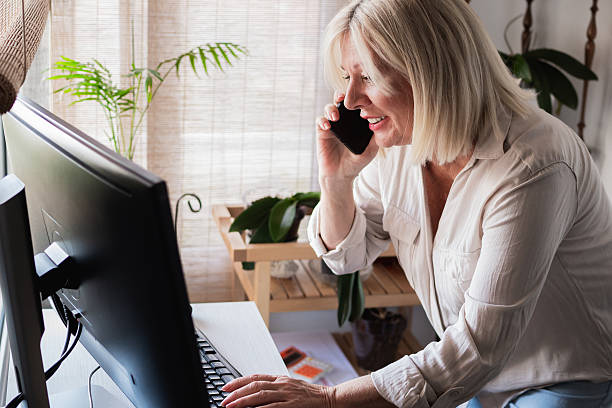 istock Senior woman working from home office making a phone call 2249432369
