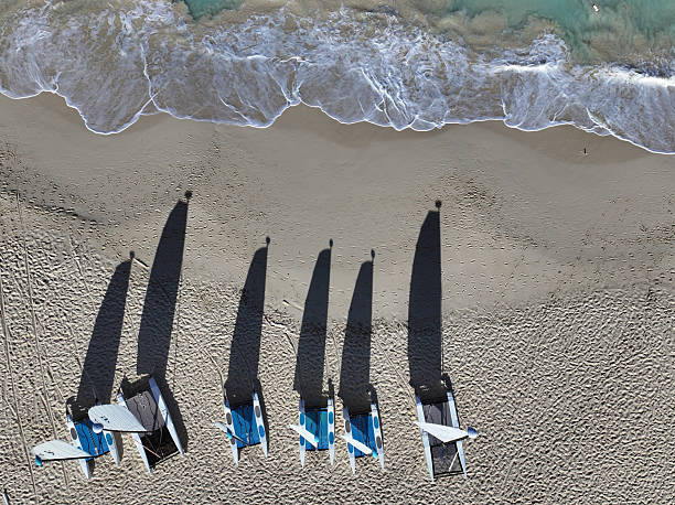A single, empty white and blue beach lounger rests on a wide stretch of sandy shore. The empty lounger symbolizes a peaceful invitation to relaxation and off-season solitude.