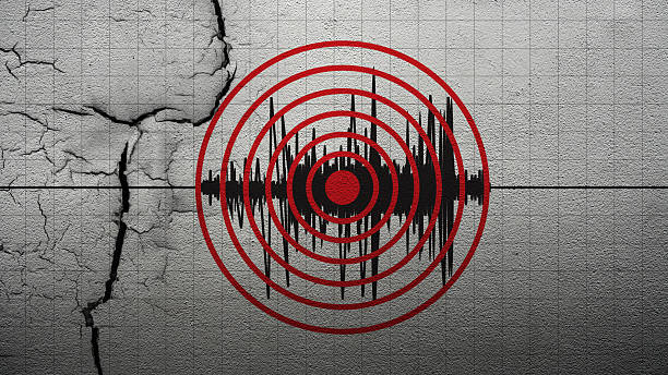Earthquake with seismic wave represented by concentric red circles, overlaid on a cracked concrete wall background. Concept of Earthquake