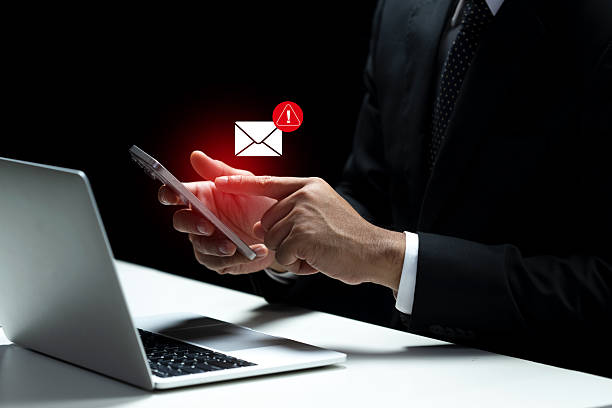 istock Businessman is checking his cellphone with a notification indicating a potentially harmful email. Concept of scam or phishing 2249445323