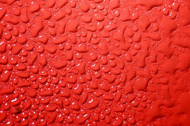 Drops on glass in abstract color lighting.