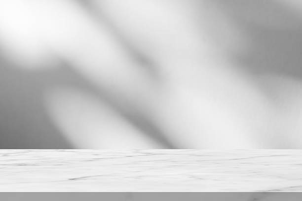 istock Marble table with tree shadow drop on white wall background for mockup product display 2249447304