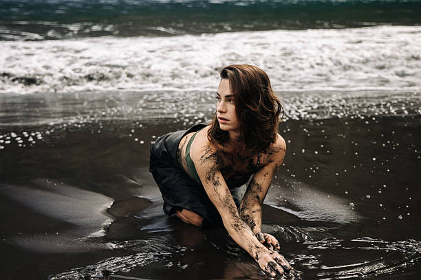A young woman on a sandy beach enjoying the serene atmosphere, surrounded by lush greenery and gentle waves, personifying tranquility and natural beauty.