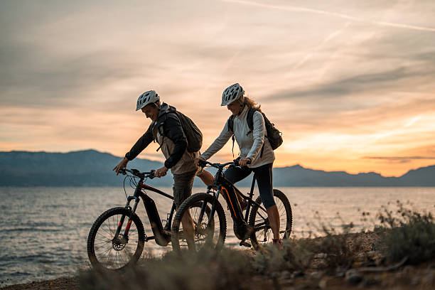 istock Active Senior Couple with Electric Bikes at Seashore Sunrise 2249449151