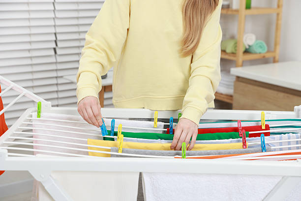 istock Woman hanging fresh clean laundry on drying rack at home, closeup 2249449529