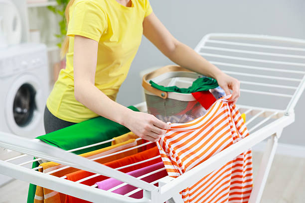 istock Woman hanging fresh clean laundry on drying rack at home, closeup 2249449532