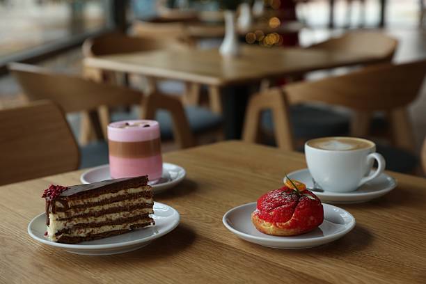 istock Aromatic coffee and delicious desserts served on wooden table in cafe 2249449761