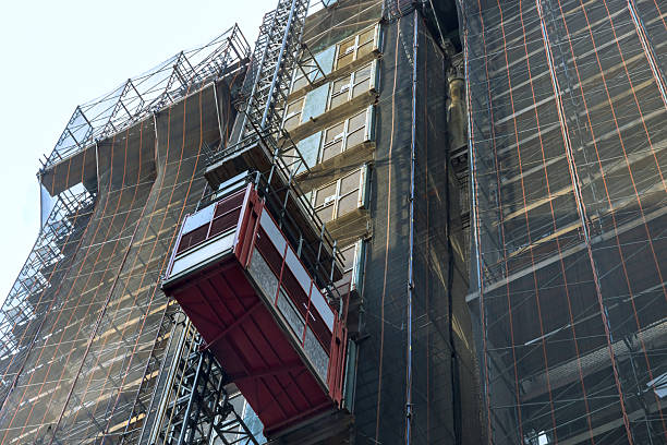 istock Construction lift at building site for high rise structure in urban area with safety place 2249452004