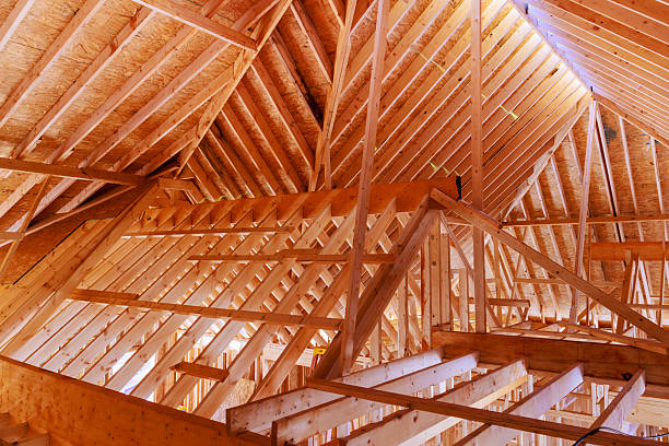 istock Structure of wooden beams rafters in house under construction 2249452472