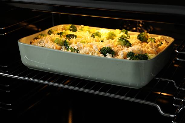 Baking dish with uncooked pasta casserole in oven, closeup