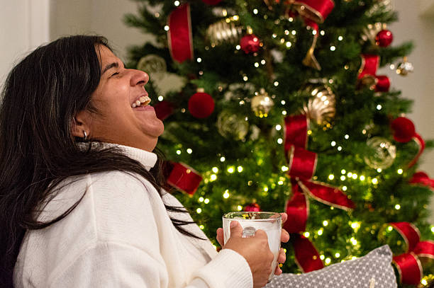 istock Smiling Woman Sitting by Decorated Christmas Tree. 2249463969