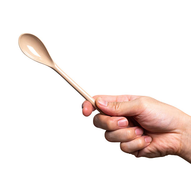 istock Male hand holding a brown plastic spoon isolated on white background. 2249464461