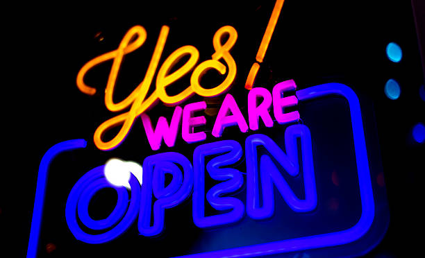 istock Colorful Neon YES WE ARE OPEN Sign in Window 2249464604
