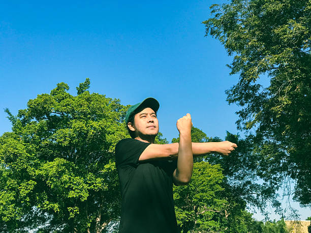Healthy man exercising in nature and stretching