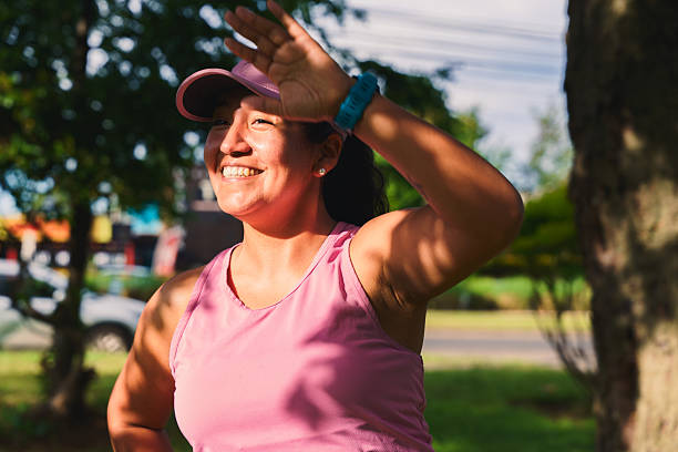 istock Woman shielding eyes from sun while smiling outdoors 2249473642