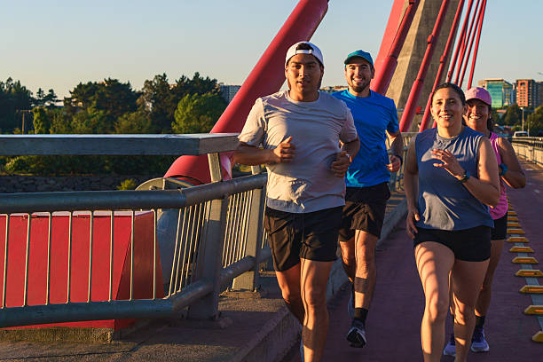 istock Group of four friends jogging on a bridge at sunset 2249473809