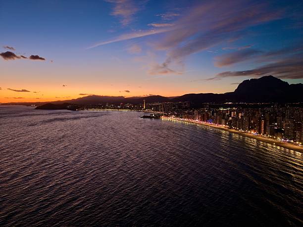 istock serene evening with coastal views, tranquil sunset over shoreline with city shining brightly at night 2249474647
