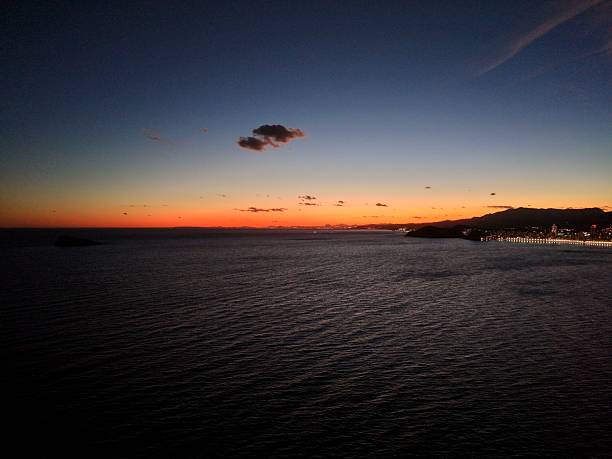 Vibrant sunset over the ocean with colorful clouds and a serene horizon, creating a picturesque evening view.