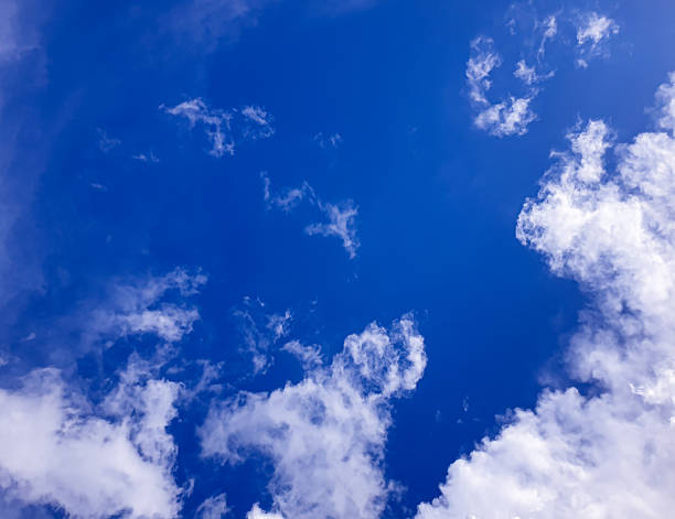 Deep blue sky framed by scattered clouds, offering a clean and minimal natural scene suitable for backgrounds, environment concepts, and fresh outdoor themed designs.