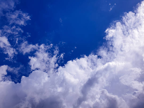 Soft billowing clouds rising into a bright blue sky, capturing a peaceful natural moment ideal for weather content, calm landscape themes, and airy background designs.