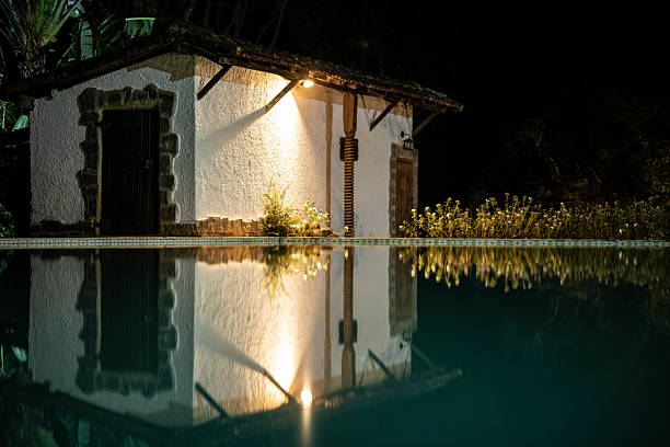 Modern private villa with swimming pool and wooden pergola illuminated by sunlight during a summer day