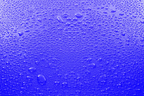 Extreme close-up of water droplets on blue background.