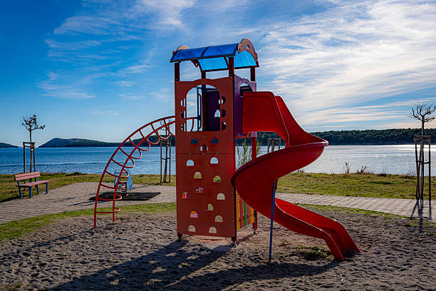 children's playground by the sea, red color, rab, croatia, mediterranean, clear, few clouds
