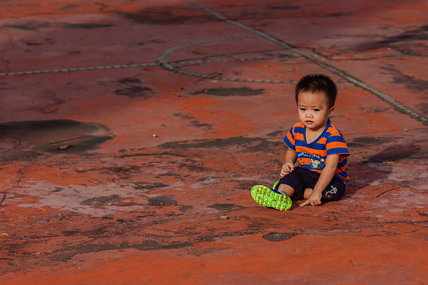 A little boy is sitting on a small boat
