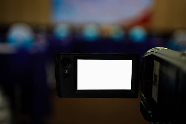 Video camera in conference room recording, with a video camera, On a blurred background, white LED display, space for text or pictures.
