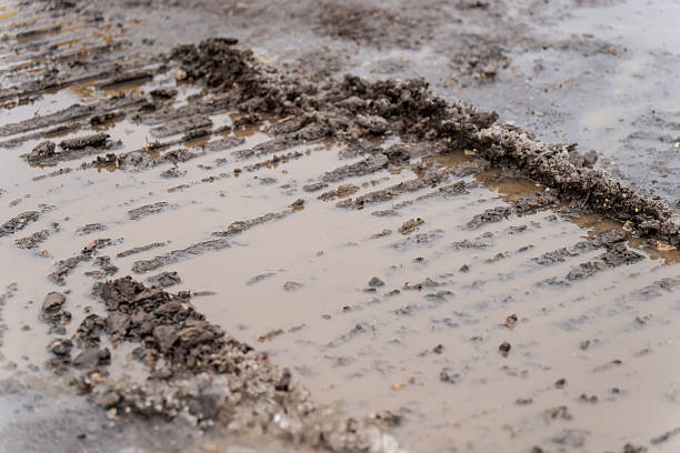 istock Deep construction vehicle tire tracks filled with water on a muddy worksite ground, showing heavy-equipment movement patterns, wet terrain conditions, and industrial site surface wear 2249489829
